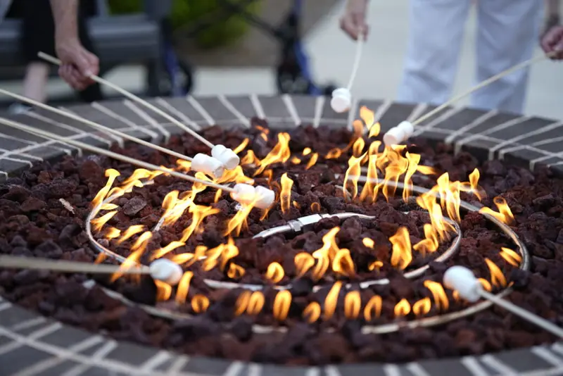 People roasting marshmallows around the community fire pit