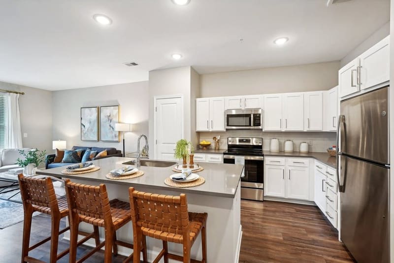 Apartment kitchen with quartz countertops, stainless steel appliances and white cabinetry